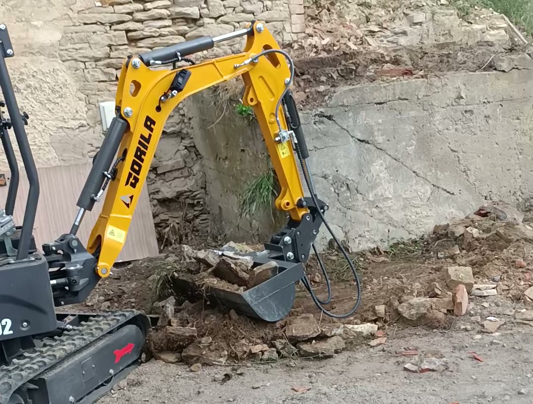 Minibagr GORILA odkopává zeminu a kameny u zdi